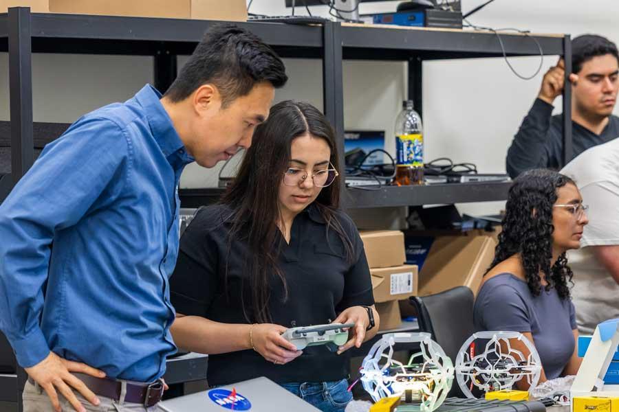 Liang Sun works with students in his Baylor laboratory.