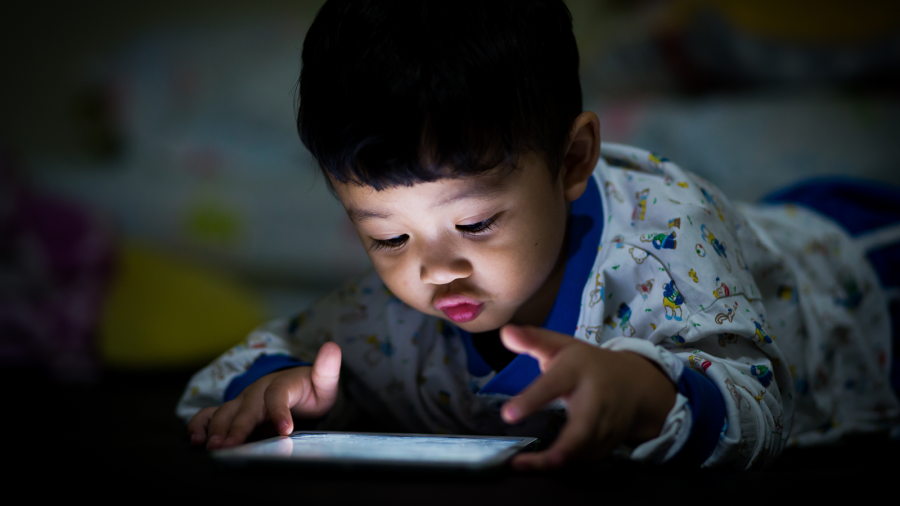 A toddler views an iPad